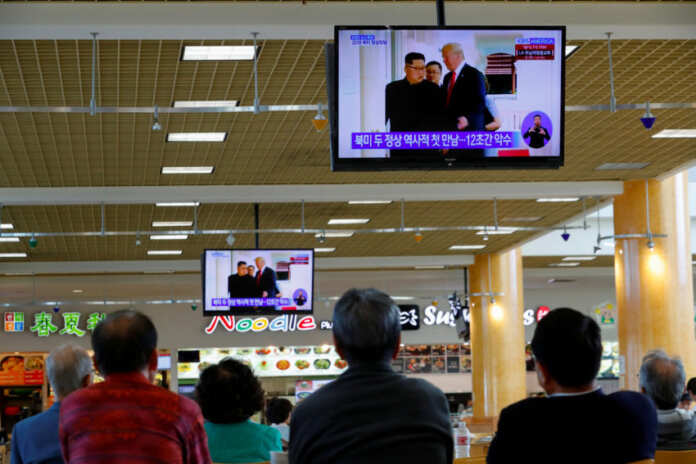 FILE PHOTO: People watch from a shopping mall food court in the Los Angeles neighborhood of Koreatown as Singapore hosts summit between U.S. President Trump and North Korean leader Kim Jong Un