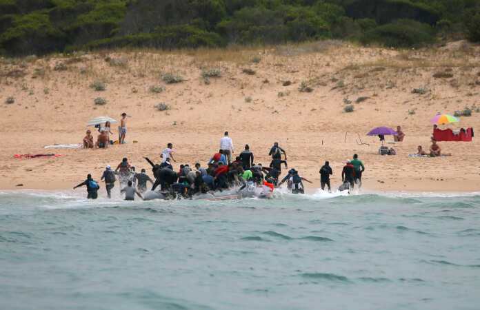 Moroccan migrants disembark from a dinghy at