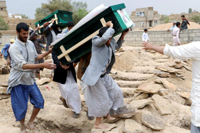 Mourners carry coffins during a funeral of people, mainly children, killed in a Saudi-led coalition air strike on a bus in northern Yemen, in Saada