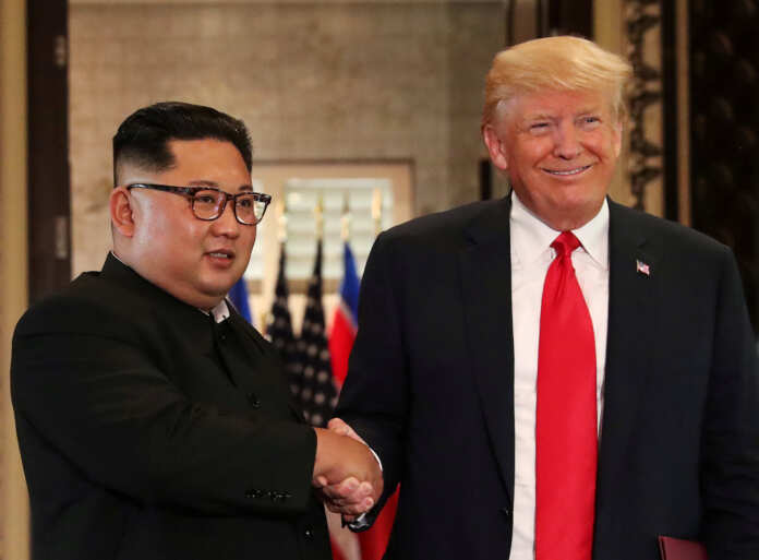 FILE PHOTO: President Donald Trump and North Korea's leader Kim Jong Un shake hands after signing documents during a summit in Singapore