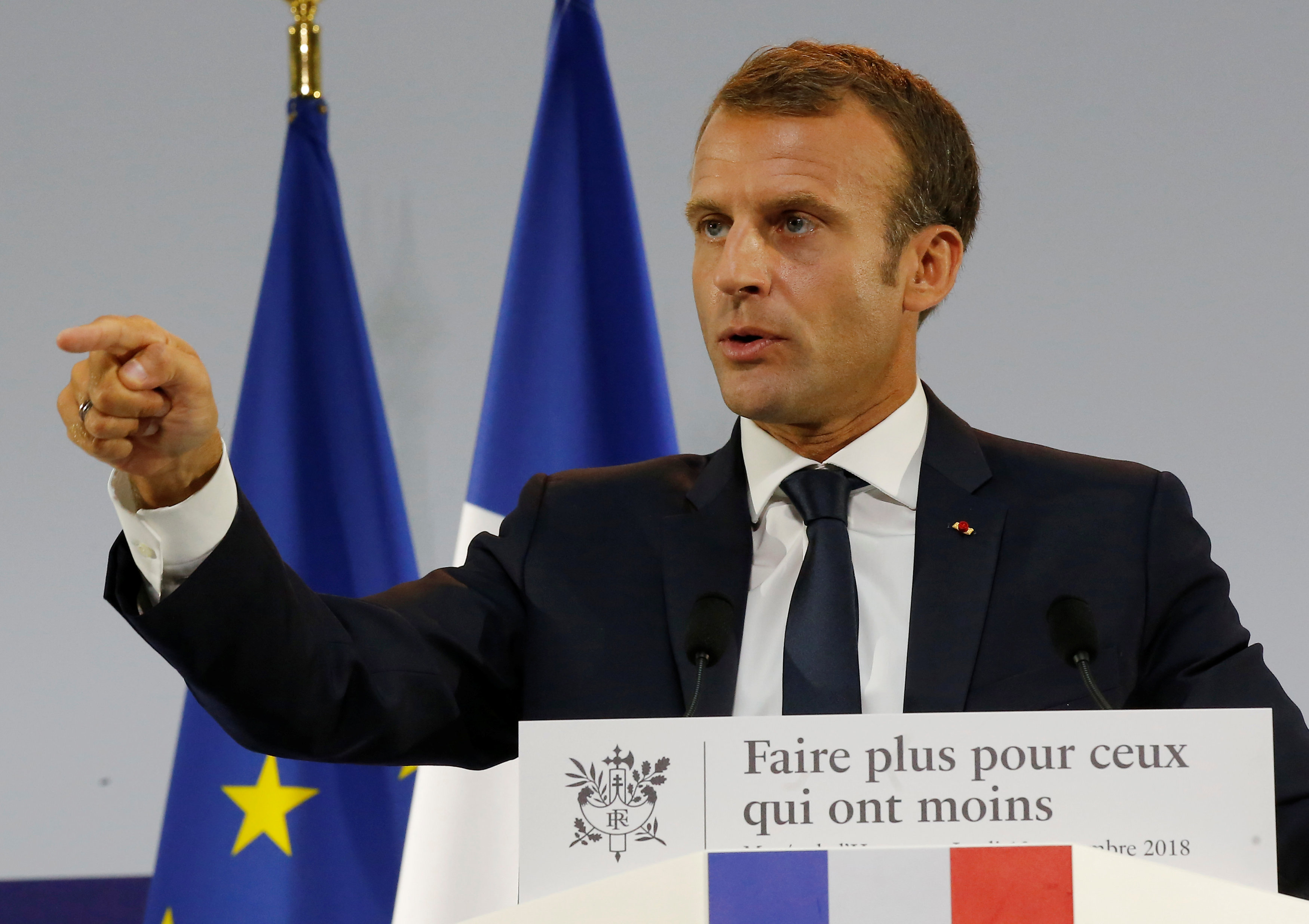 French President Emmanuel Macron gestures as he delivers a speech on poverty to social aid workers in Paris
