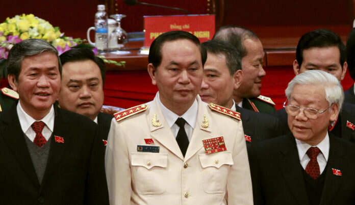 FILE PHOTO: Vietnam's Public Security (Police) Minister Quang stands with Communist Party Chief Trong and Politburo member Huynh at a closing ceremony of 12th National Congress of the Party in Hanoi