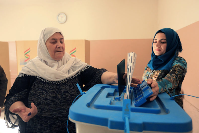 A Kurdish woman casts her vote at a polling station, during parliamentary elections in the semi-autonomous region in Duhok