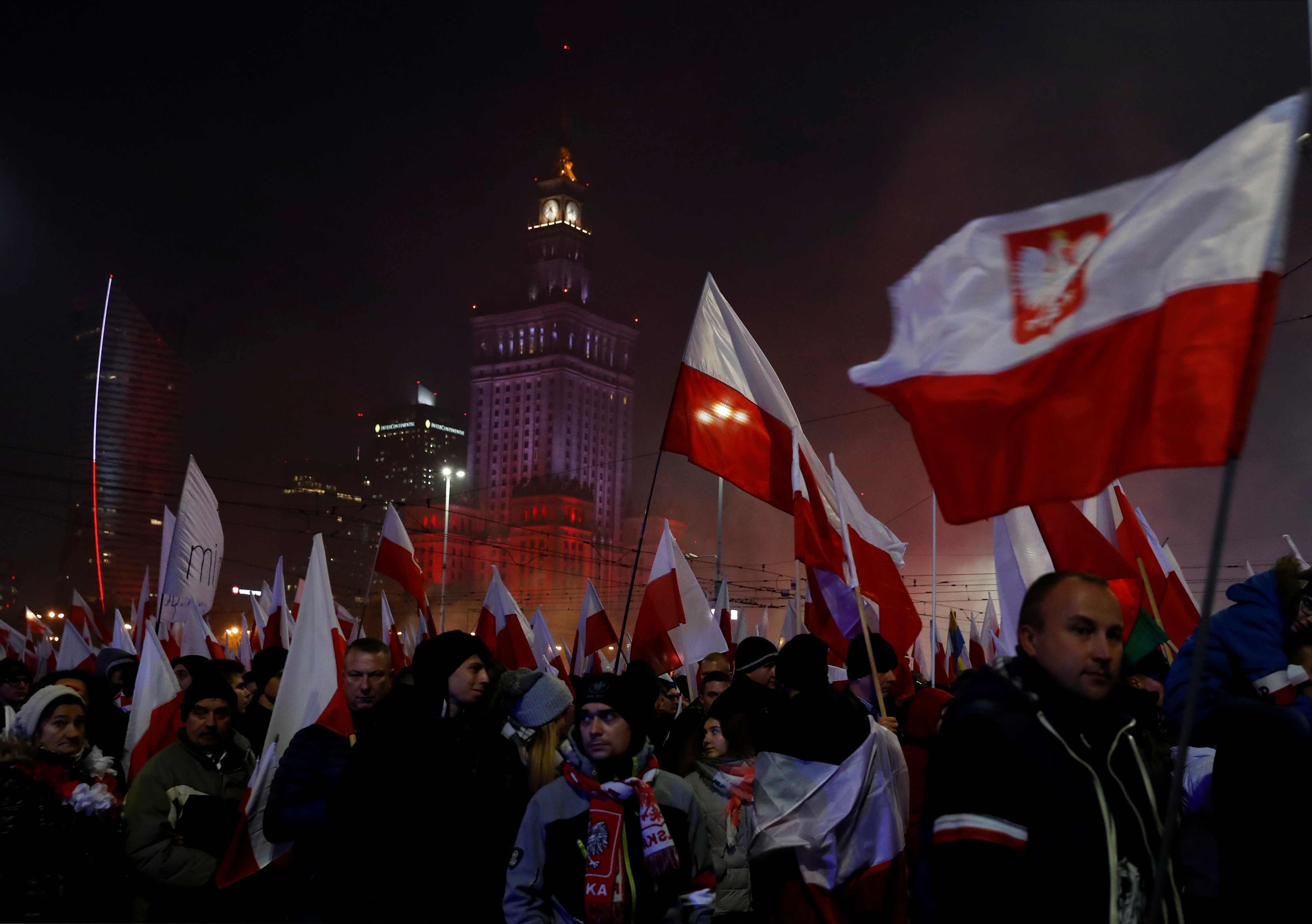 People carry Polish flags during a march marking the 100th anniversary of Polish independence in Warsaw