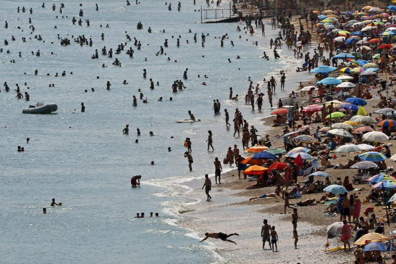 Tourists enjoy the hot weather at Vari beach, southeast of Athens