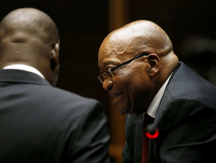 Former South African President Jacob Zuma speaks with counsel at court ahead of his court appearance in Pietermaritzburg