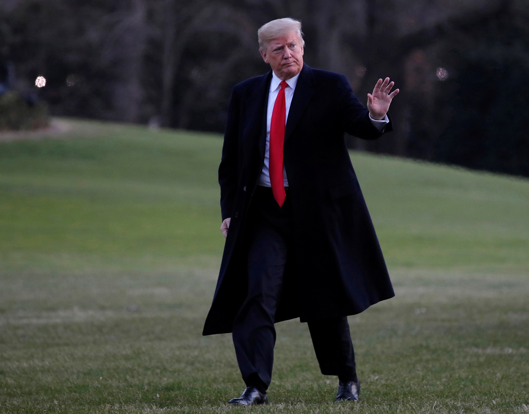 U.S. President Donald Trump walks across the South Lawn after returning to the White House in Washington