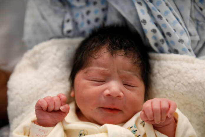 The Wider Image: New mother on migrant caravan hopes Trump's heart softens