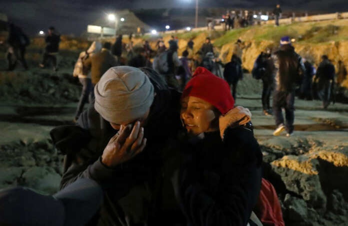 Migrants are seen injured after U.S. CBP throw tear gas to the Mexican side of the fence as they prepared to cross it illegally, in Tijuana