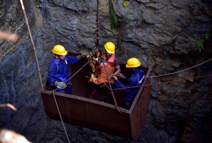 Divers use a pulley to enter a coal mine that collapsed in Ksan