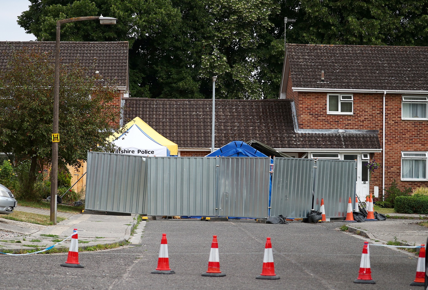 A barrier and a police tent stand outside Sergei Skripal's home in Salisbury