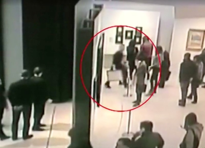 A screen grab taken from video footage shows a man walking with a painting by prominent artist Arkhip Kuindzhi at Tretyakov art gallery in Moscow