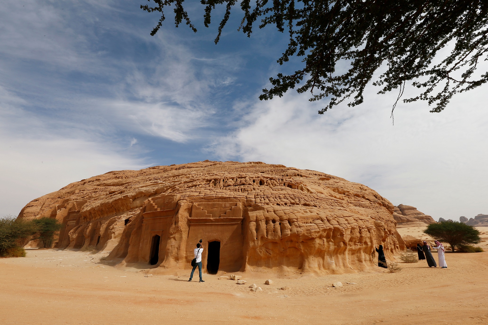 Visitors take pictures at majestic rock-hewn tombs of Madain Saleh near the city al-Ula