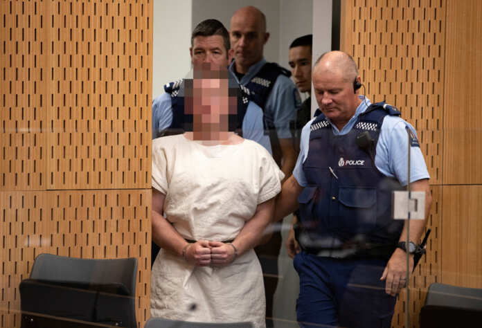 Brenton Tarrant, charged for murder in relation to the mosque attacks, is lead into the dock for his appearance in the Christchurch District Court