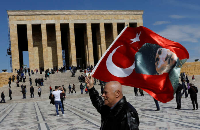A man waves a Turkish flag with a portrait of modern Turkey's founder Mustafa Kemal Ataturk as he visits Anitkabir, the mausoleum of Ataturk, in Ankara