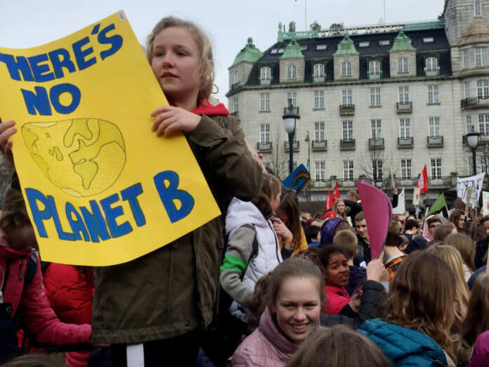 FILE PHOTO: A student holds a placard during a protest against climate change in front of the Parliament building in Oslo