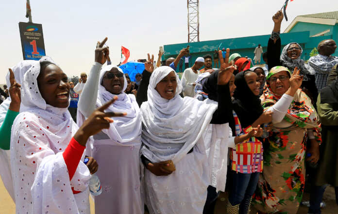 Sudanese demonstrators chant slogans as they protest against the army's announcement that President Omar al-Bashir would be replaced by a military-led transitional council, near Defence Ministry in Khartoum