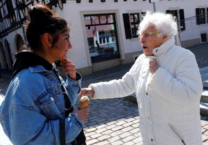 Lisel Heise, a 100-year-old former teacher, greets a teenager as she walks through Kirchheimbolanden