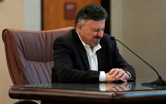 Frank DeAngelis listens during a news conference after an armed woman