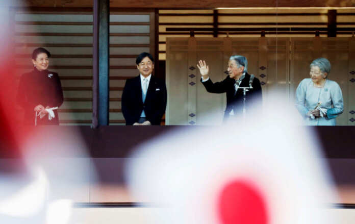 FILE PHOTO: Japan's Emperor Akihito waves to well-wishers during a public appearance for New Year celebrations at the Imperial Palace in Tokyo