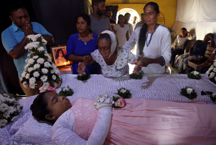 The injured grandmother of Shaini, 13, who died as bomb blasts ripped through churches and luxury hotels on Easter, mourns at her wake, in Negombo