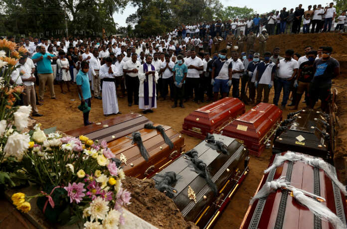 FILE PHOTO: People participate in a mass funeral in Negombo