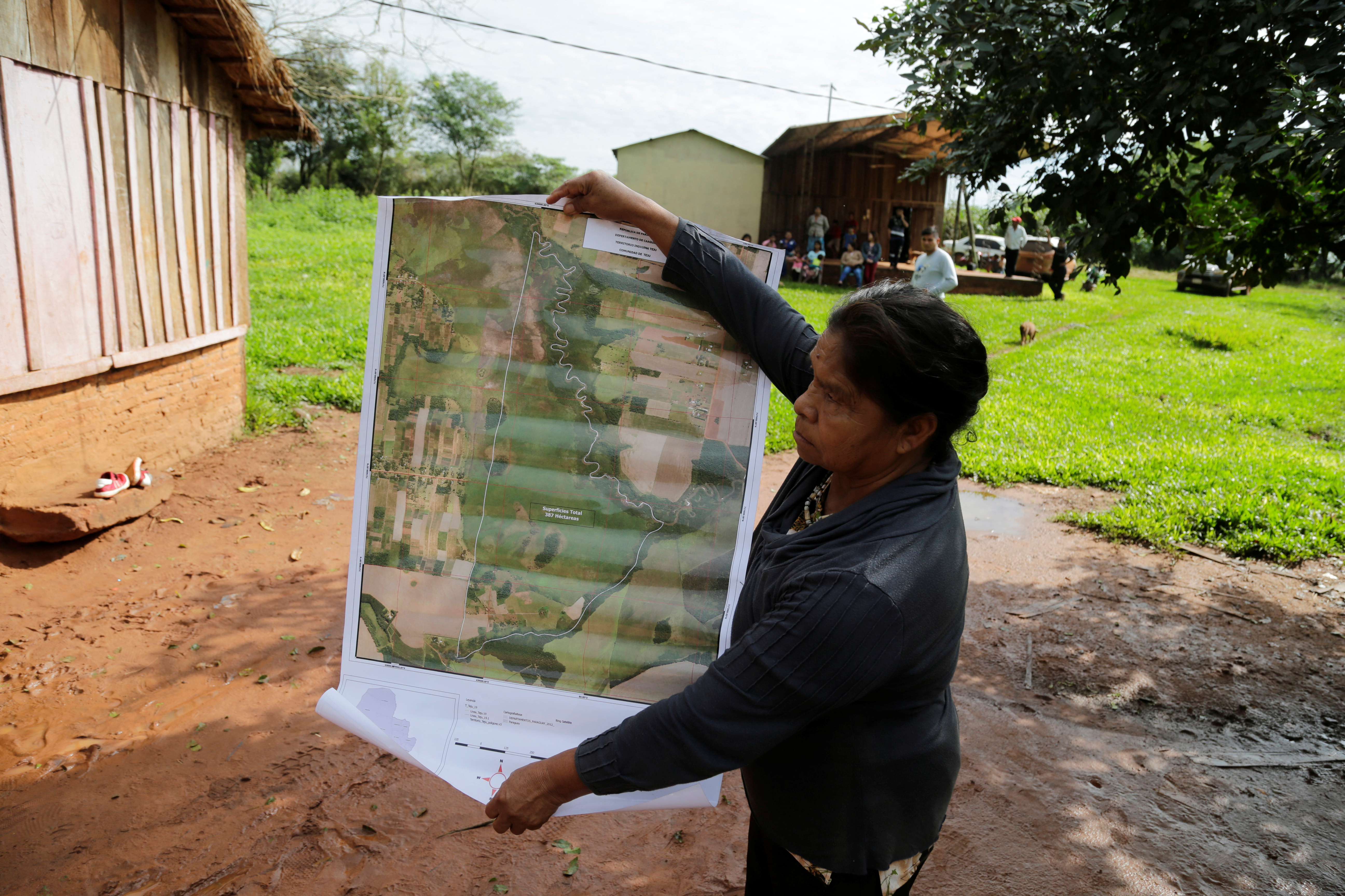 Community leader Cornelia Flores holds a map showing the community's territory, in Isla Jovai Teju