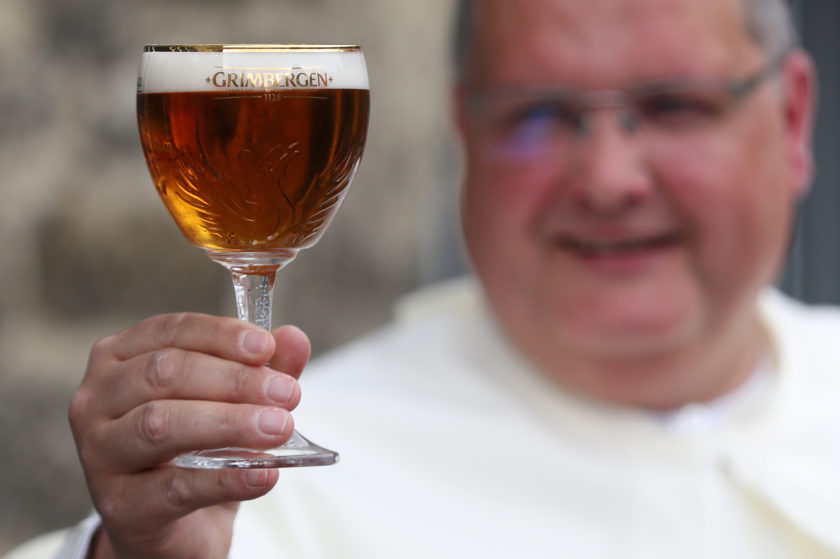 Norbertine Father Karel poses with a Grimbergen beer, symbolised by a phoenix, in the courtyard of the Belgian Abbey of Grimbergen before announcing that the monks will return to brewing after a break of two centuries, in Grimbergen