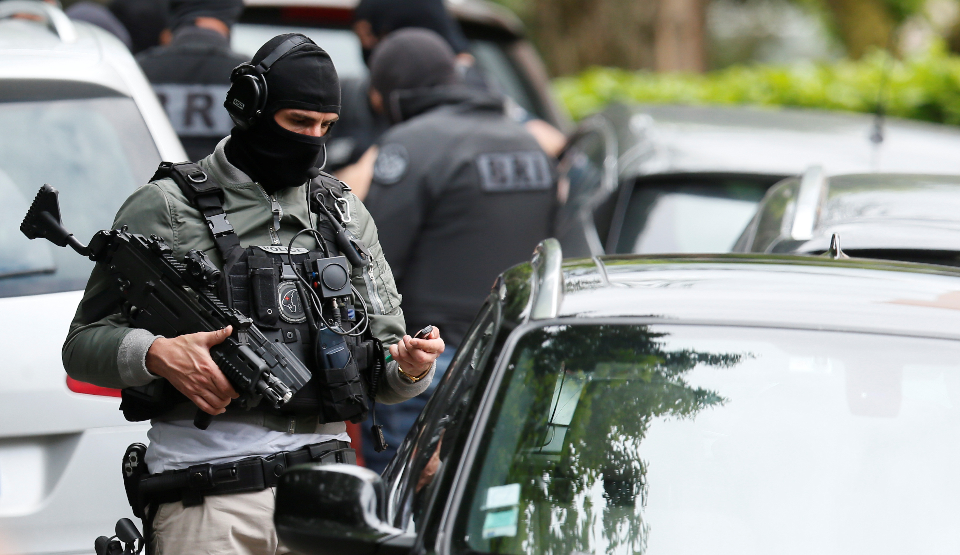 Investigators are seen during a police operation in Oullins, near Lyon