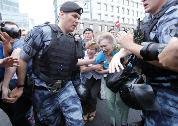Women react as members of Russia's National Guard detain participants of a rally in support of Russian investigative journalist Ivan Golunov in Moscow