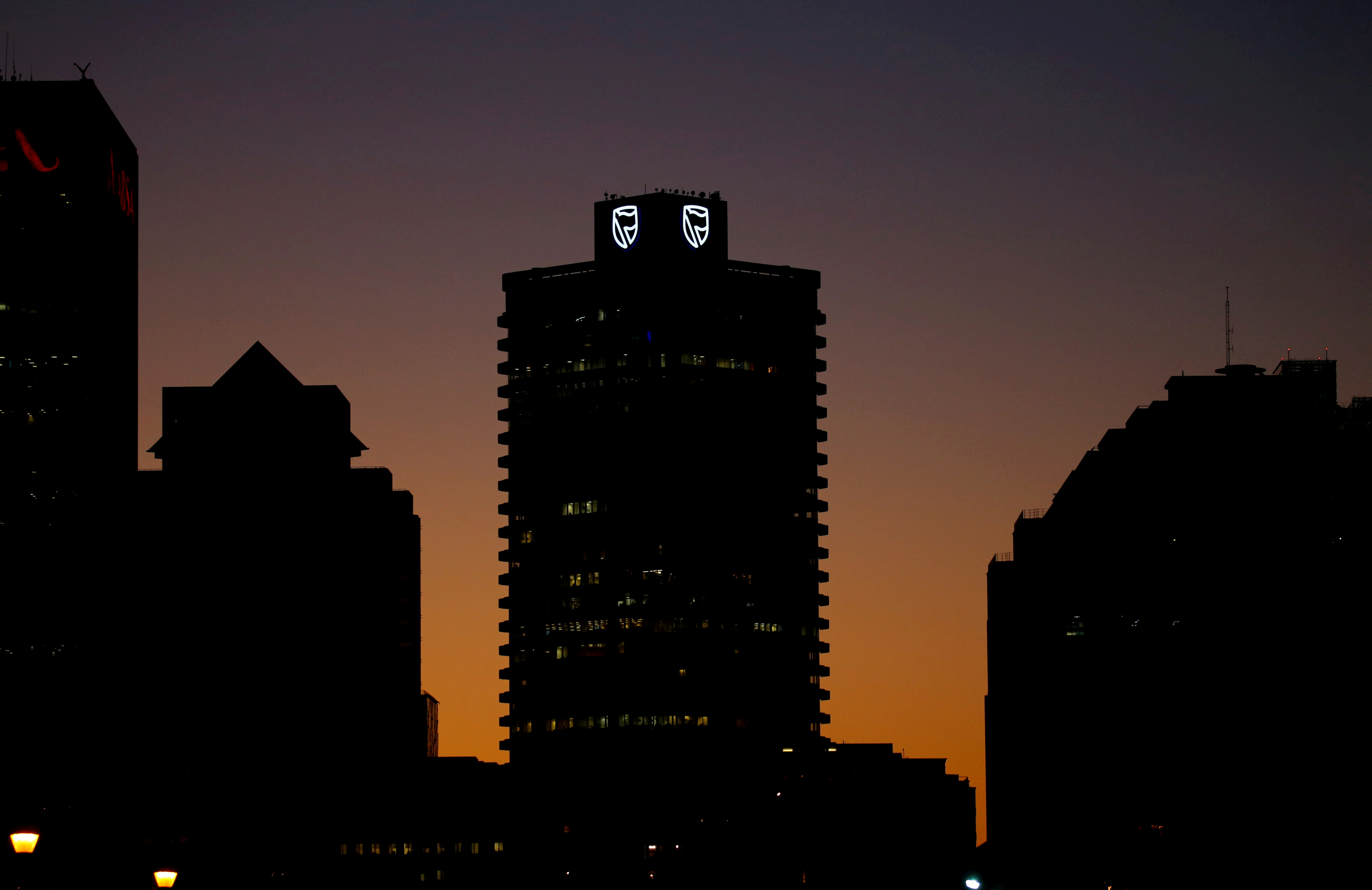 FILE PHOTO: The logo of South Africa's Standard Bank is seen above the company's headquarters in Cape Town