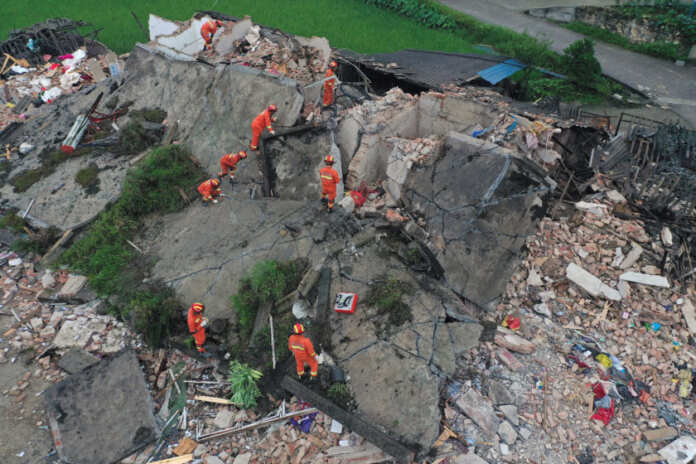 Rescue workers are seen on a collapsed house after earthquakes hit Changning county in Yibin, Sichuan