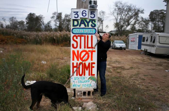 FILE PHOTO: Laurie changes the numbers on sign she erected across road from where her house once stood before being destroyed by hurricane Sandy in October of 2012 in Ocean Breeze section of Staten Island