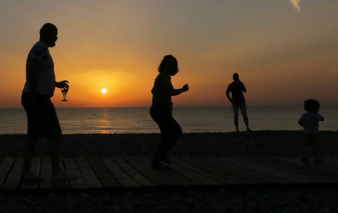 People enjoy sunset on the beach, as the heatwave hits France, in Cayeux-sur-Mer