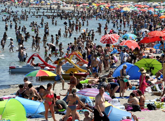People sunbath at a beach by the Baltic Sea in Timmendorfer Strand