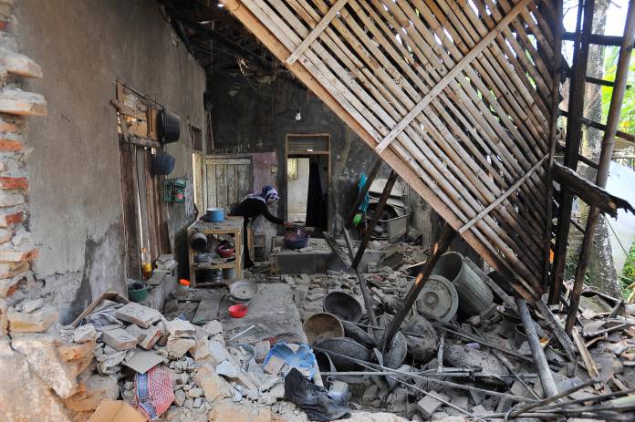 Woman is seen inside her house damaged after an earthquake hit in Pandeglang