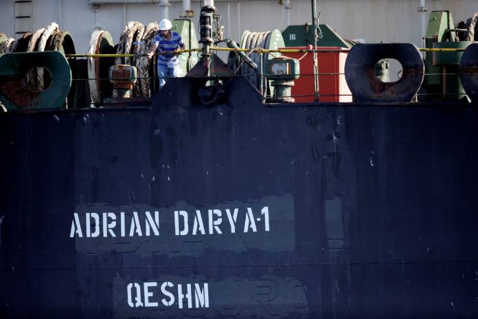 A crew member takes pictures with a mobile phone of Iranian oil tanker Adrian Darya 1, previously named Grace 1, as it sits anchored after the Supreme Court of the British territory lifted its detention order, in the Strait of Gibraltar