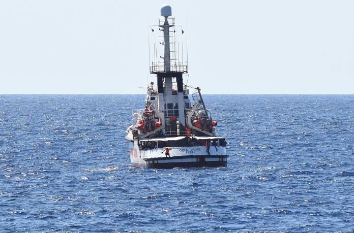 Migrants jump off the Spanish rescue ship Open Arms, close to the Italian shore in Lampedusa