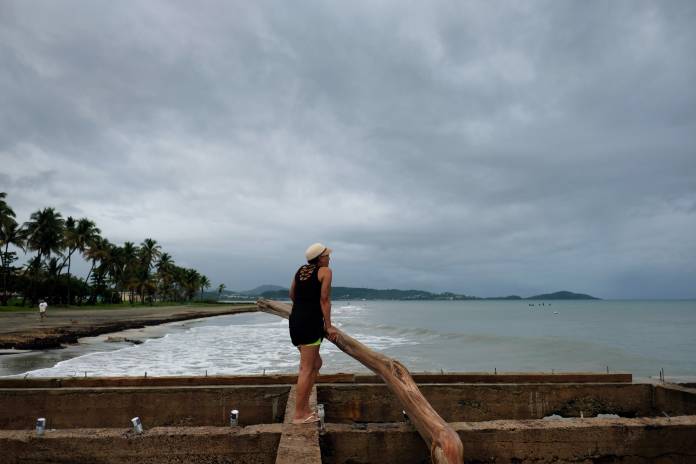 Woman surveys the beach as Tropical Storm Dorian approaches in Humacao