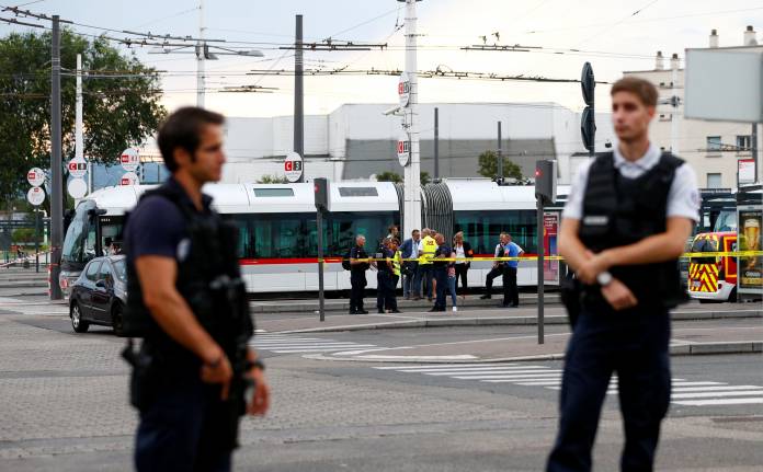 French police secure the area after one person was found dead and six others wounded in a suspected knife attack in Villeurbanne, near Lyon