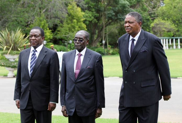 FILE PHOTO: Then-Zimbabwe President Robert Mugabe is seen with vice presidents Phelekezela Mphoko (R) and Emmerson Mnangagwa (L) at State House in Harare