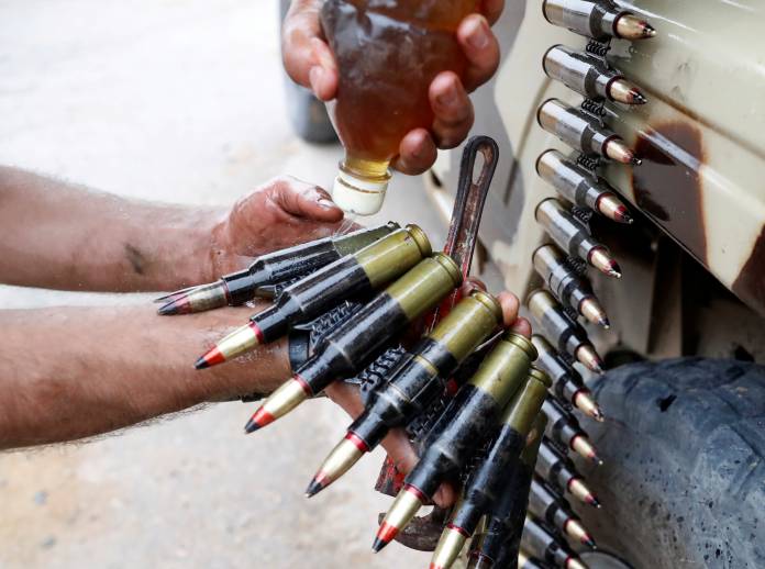 FILE PHOTO: A fighter loyal to Libya's U.N.-backed government (GNA) oils bullets during clashes with forces loyal to Khalifa Haftar on the outskirts of Tripoli