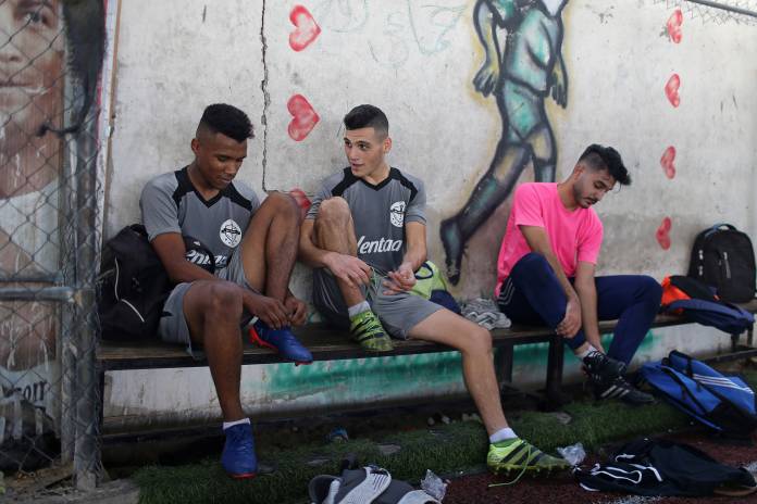 Palestinian players of Gaza soccer club Khadamat Rafah take off their boots after a training session in Rafah in the southern Gaza Strip