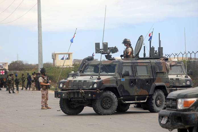 Italian security forces are seen near armoured vehicles at the scene of an attack on an Italian military convoy in Mogadishu