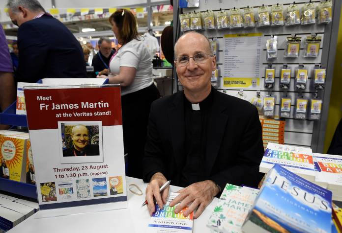 FILE PHOTO: Jesuit priest father James Martin of the U.S. signs copies of his book at the Pastoral Congress at the World Meeting of Families in Dublin, Ireland