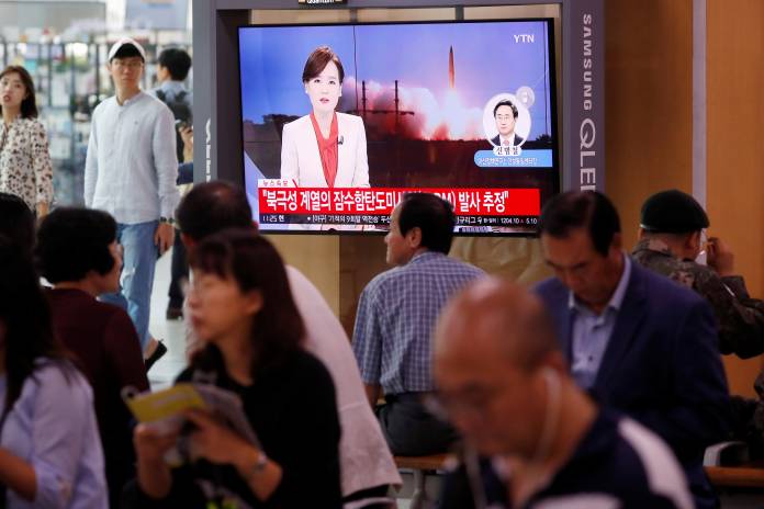People watch a TV screening of a file footage in Seoul following North Korea's firing of missile believed to be launched from a submarine