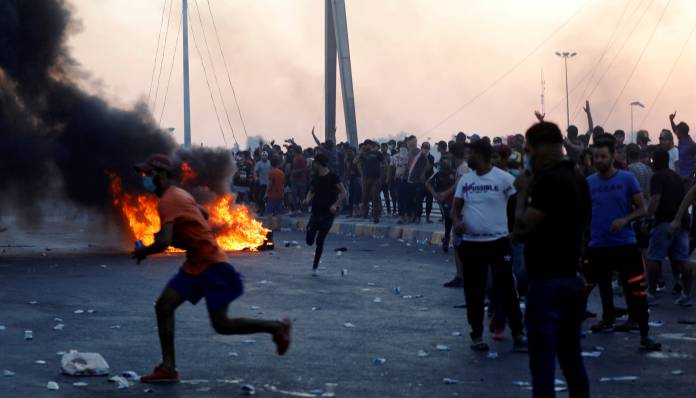 FILE PHOTO: Demonstrators gather during a protest after the lifting of the curfew, following four days of nationwide anti-government protests, in Baghdad, Iraq