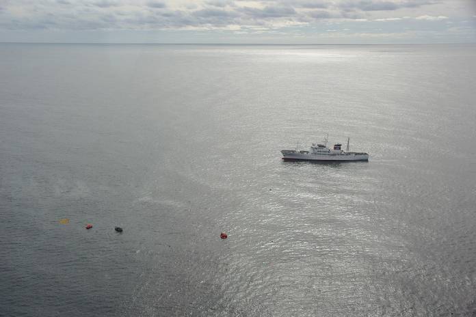 A Japanese boat (top R), which belongs to the Fisheries Agency, commence rescue work as a life boat from a North Korean fishing vessel (bottom R) floats in the sea, northwest of Noto Peninsular