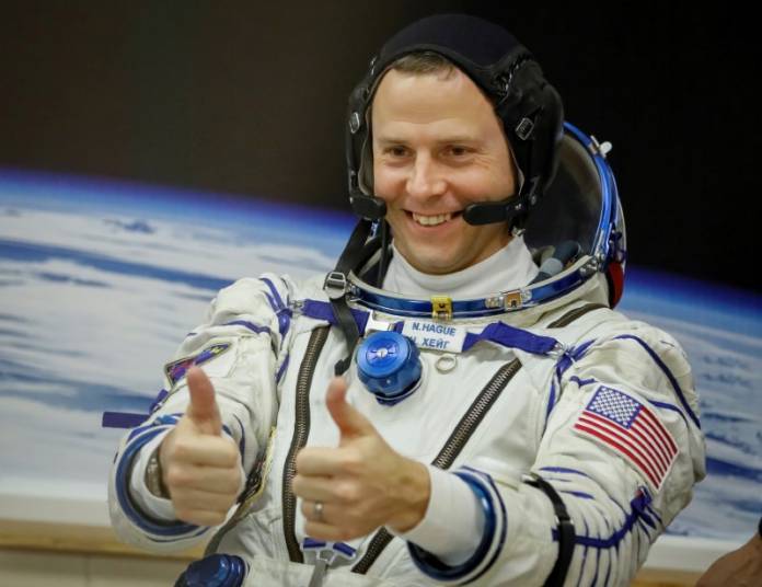 FILE PHOTO: The International Space Station (ISS) crew member Nick Hague of the U.S. gestures after donning space suits shortly before launch at the Baikonur Cosmodrome