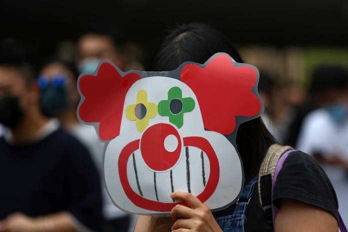 A demonstrator holds up a sign during a protest against what they say is the abuse of pro-democracy protesters by Hong Kong police, at Chater Garden in Central district